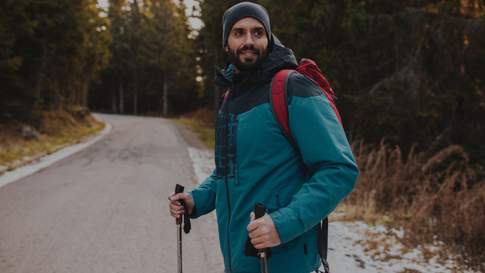 Man with hiking gear standing on a forest path