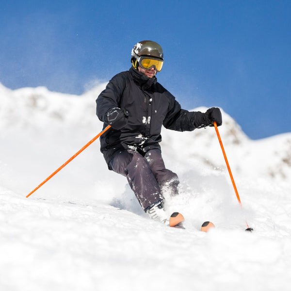 Skier in action on a snowy slope with a clear blue sky